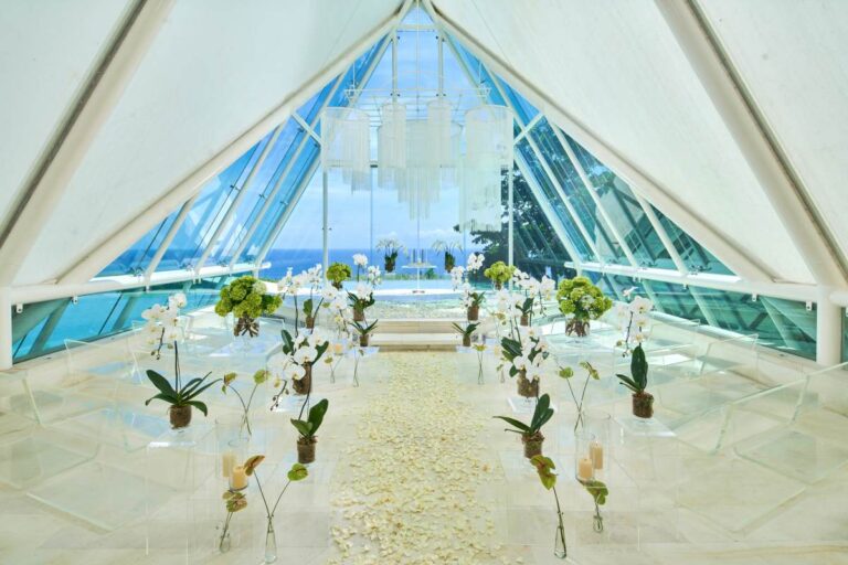 The aisle inside the Glass Chapel, dressed with white flowers, Tirtha Bridal