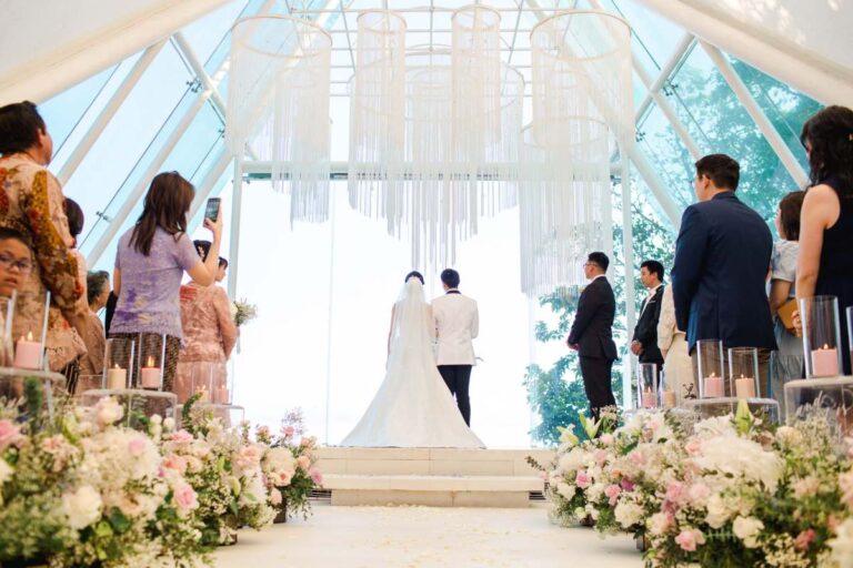 A couple at the altar of the Glass Chapel with their guests, Tirtha Bridal