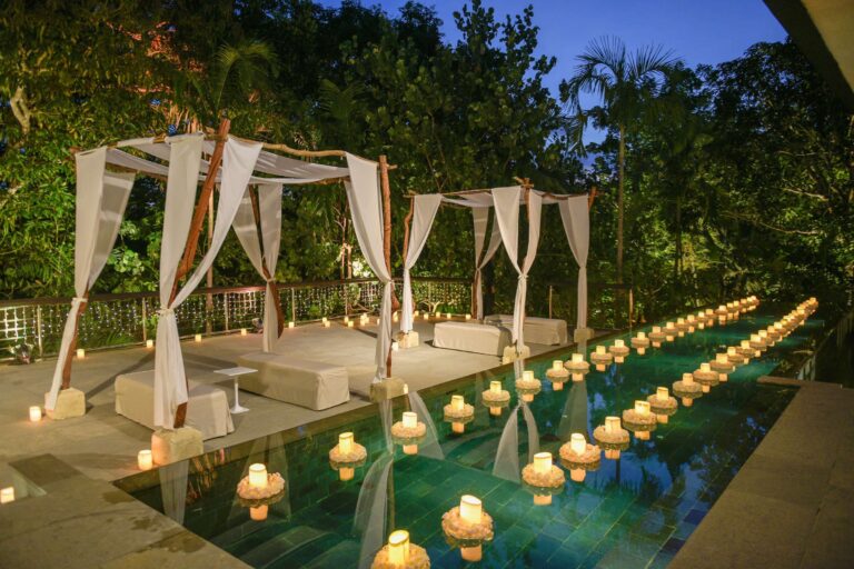 The Pool Terrace at Glass House lit with candles at night, Tirtha Bridal