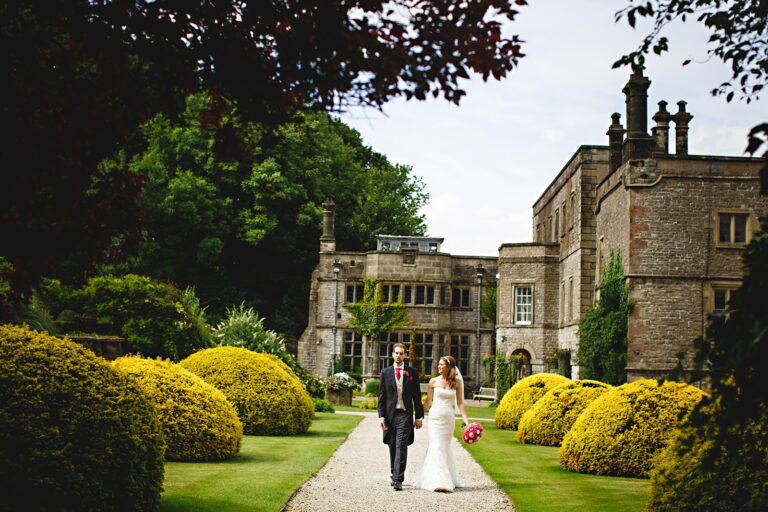 Couple crossing the topiary lawns, Tissington Hall