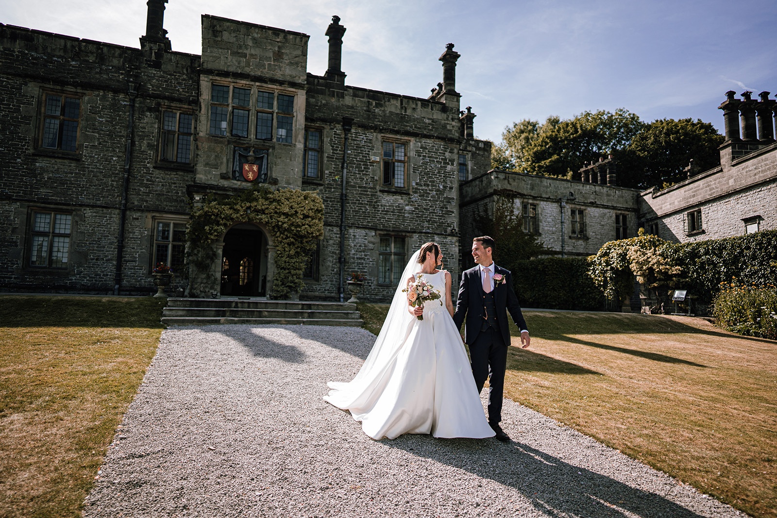 Bride and groom on the gravel drive before the hall, Tissington Hall