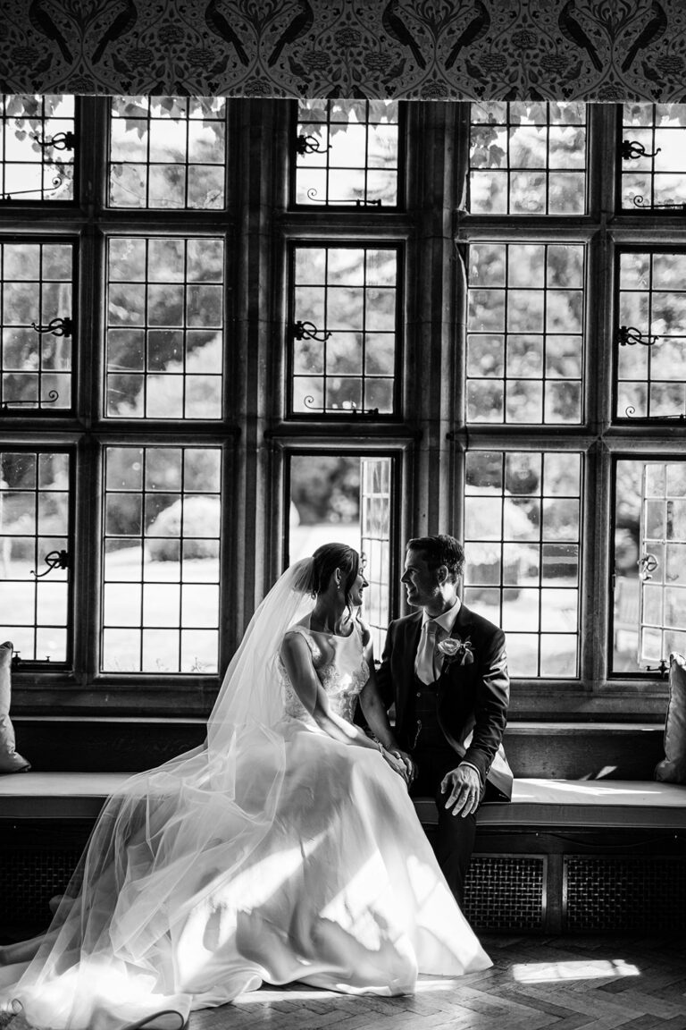 Couple in the Great Hall by its mullioned windows, Tissington Hall