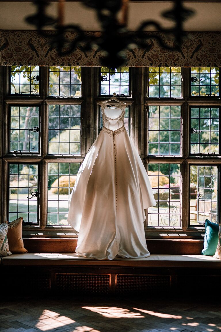 Wedding dress hung in the panelled Great Hall window, Tissington Hall