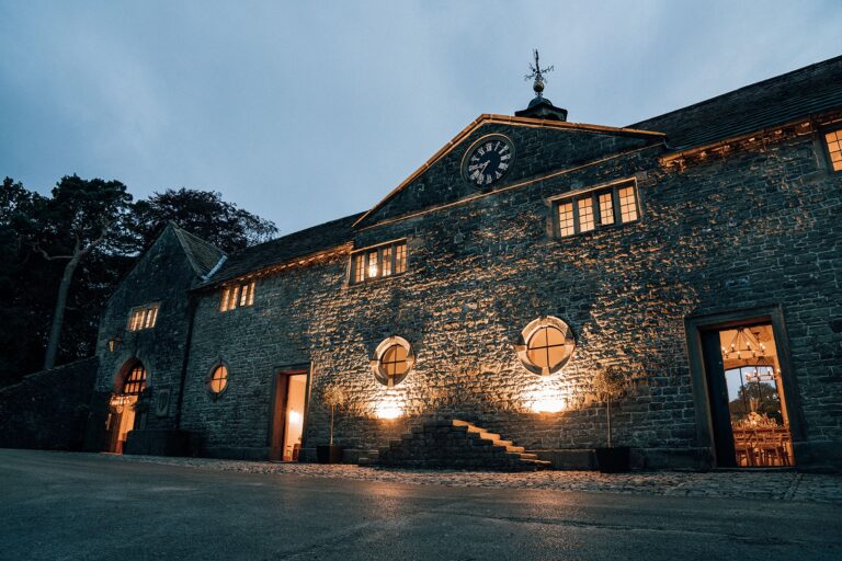 The Carriage House barn floodlit at dusk, Tissington Hall