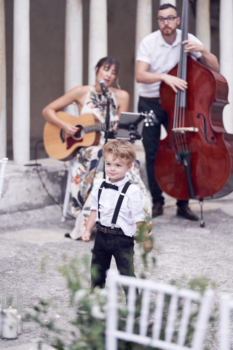 Duo playing at a ceremony as a young guest watches, Tobi Tobi