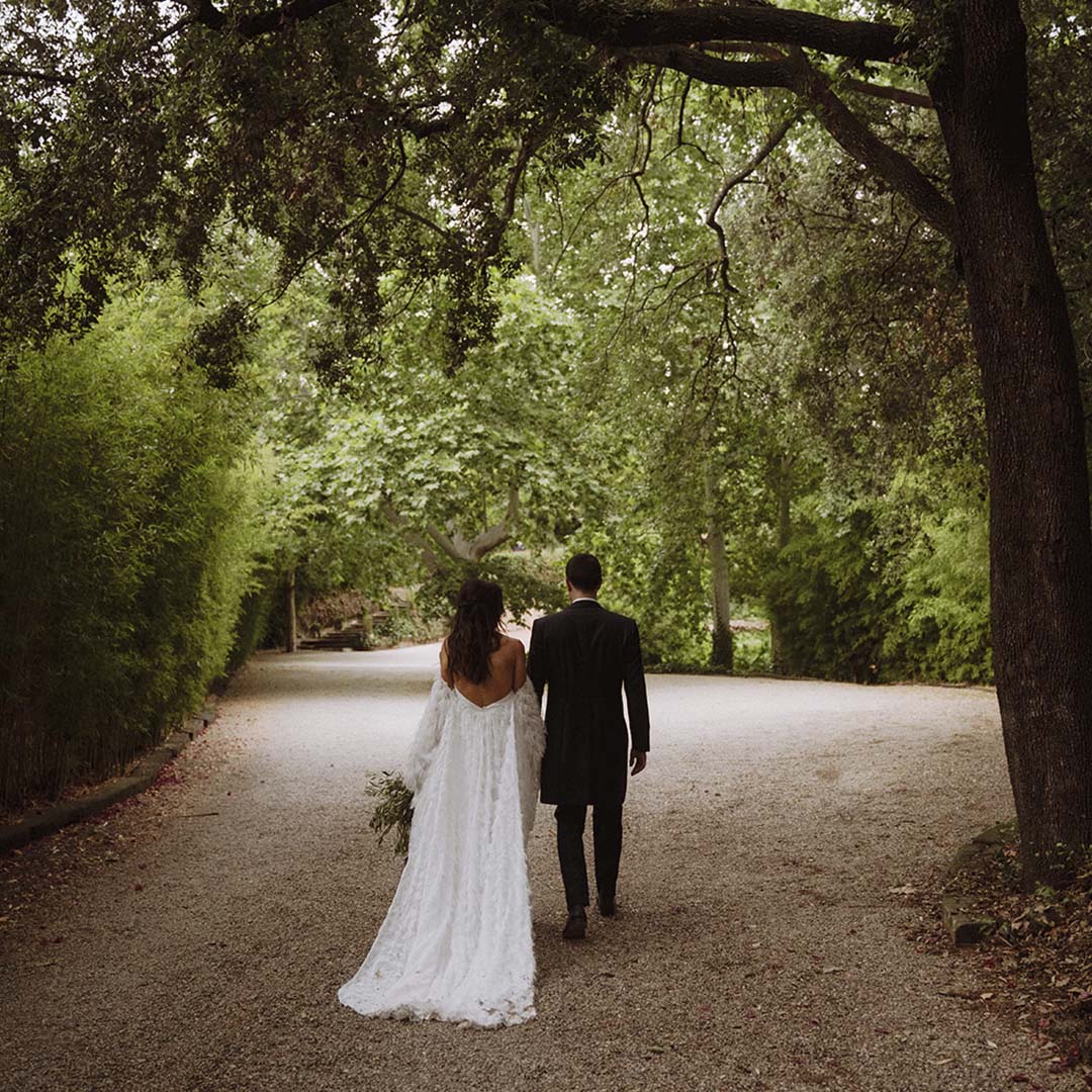 A couple walking away along a tree-lined gravel track, Torre Sever