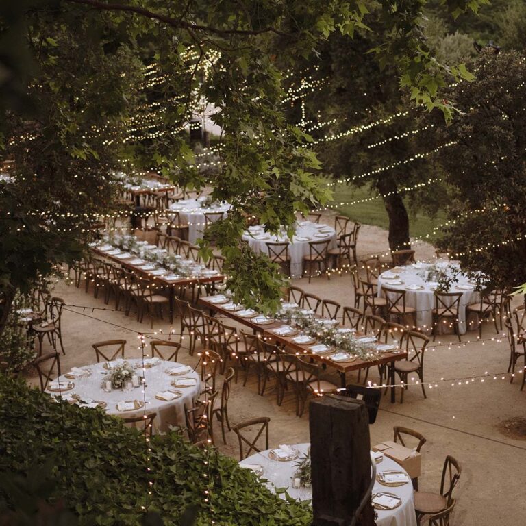 Outdoor dinner among the trees under string lights, Torre Sever