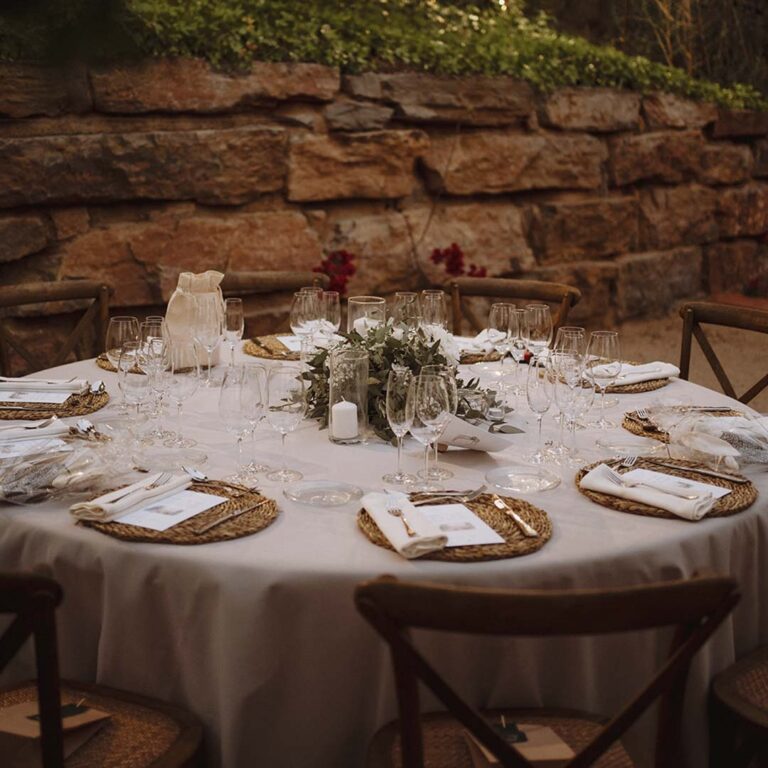 Round tables set against the stone terrace wall, Torre Sever