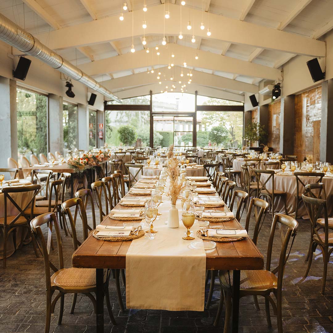 The hall with a long table and strings of lights under a timber ceiling, Torre Sever