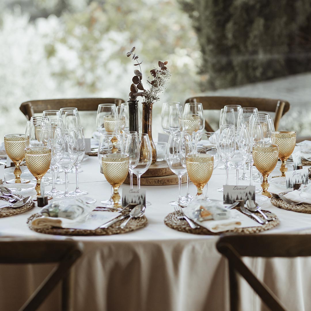 A dinner table set with amber glasses and woven place mats, Torre Sever