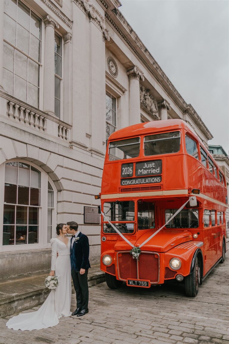 A couple outside the house beside a red Routemaster bus decorated for the wedding, Trinity House on Tower Hill