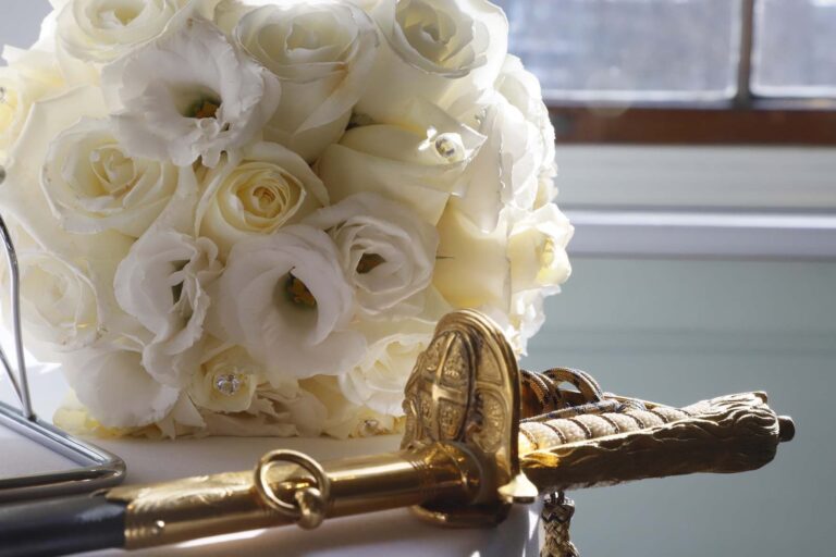 The ceremonial sword used for cutting the cake, beside a bouquet of white roses and lisianthus, Trinity House on Tower Hill