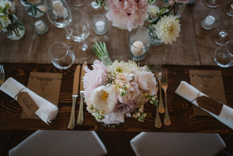 Overhead view of a place setting with peonies, candles and a handwritten menu, Tuscan DMC