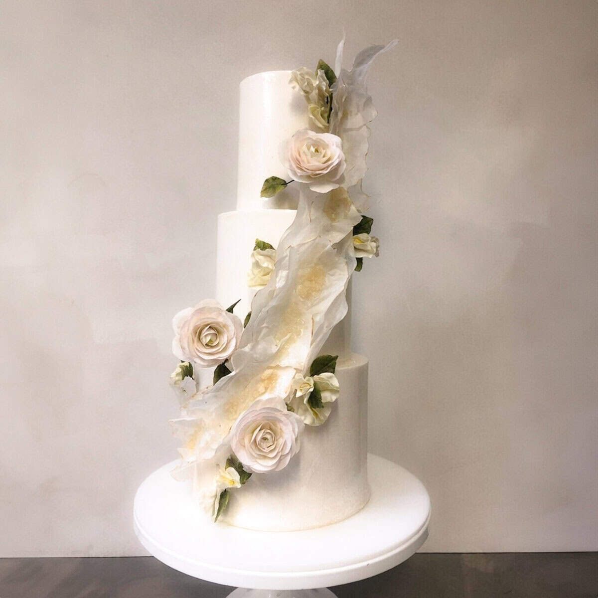 White tiered wedding cake with sculptural ruffle detail and handcrafted sugar roses at Villa Mangiacane in Tuscany, Italy., Tuscan Wedding Cakes