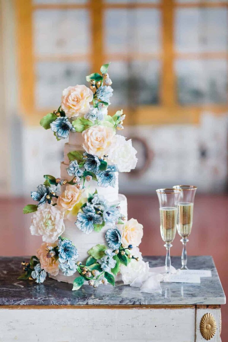 Four tier white wedding cake with a cascade of blue hand-painted sugar flowers and peach roses at Villa Corsini, Florence, Tuscan Wedding Cakes