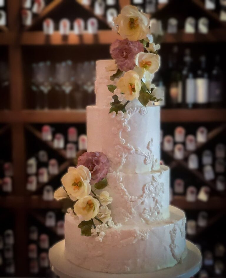 White tiered wedding cake with bas-relief detailing and sugar flowers at Villa San Michele in Fiesole, Italy., Tuscan Wedding Cakes