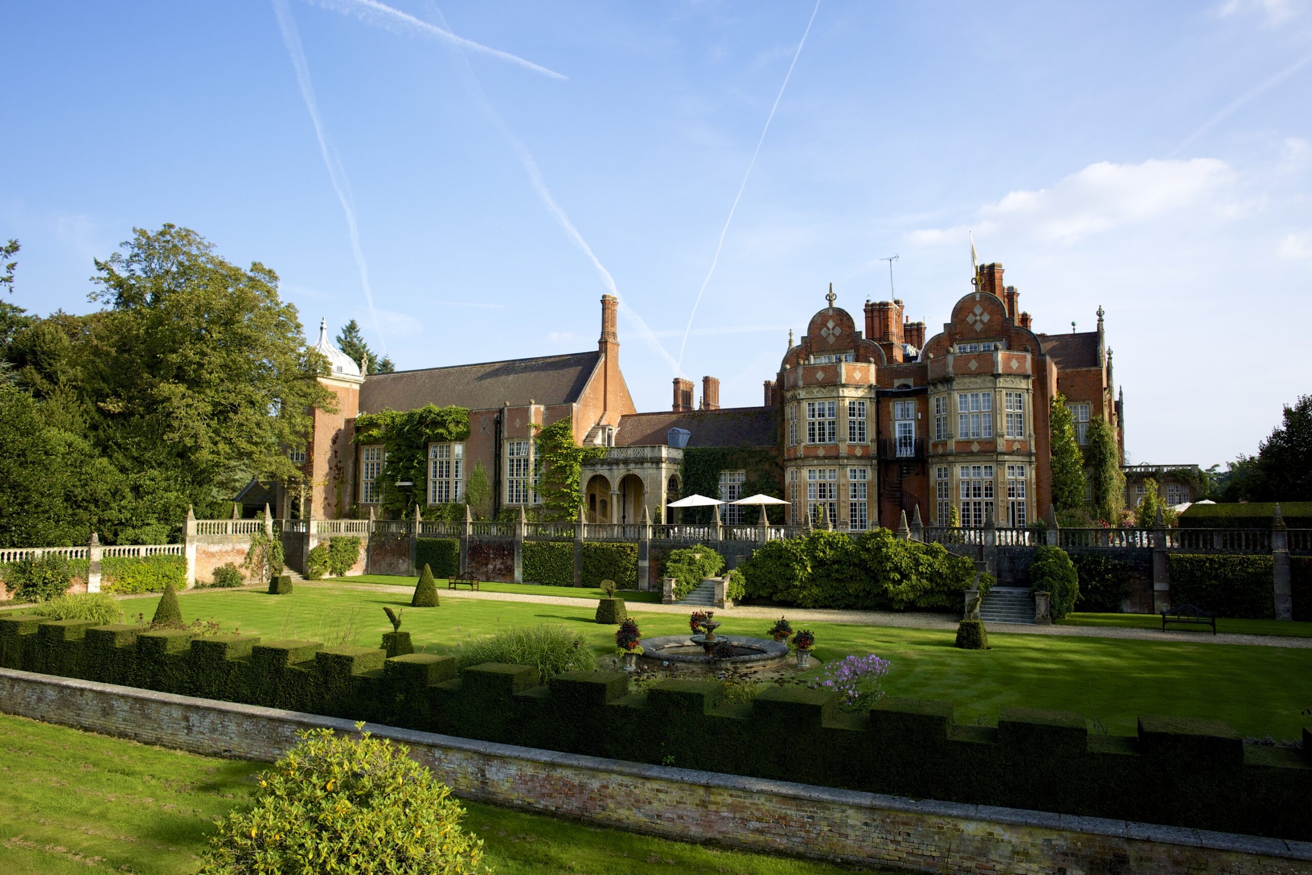 Tylney Hall Hotel, the Victorian red brick mansion seen from its formal gardens in summer sunshine