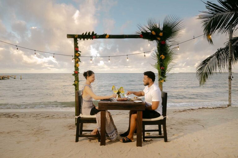 Beach table set beneath a palm-dressed arch, Umaya Resort and Adventures