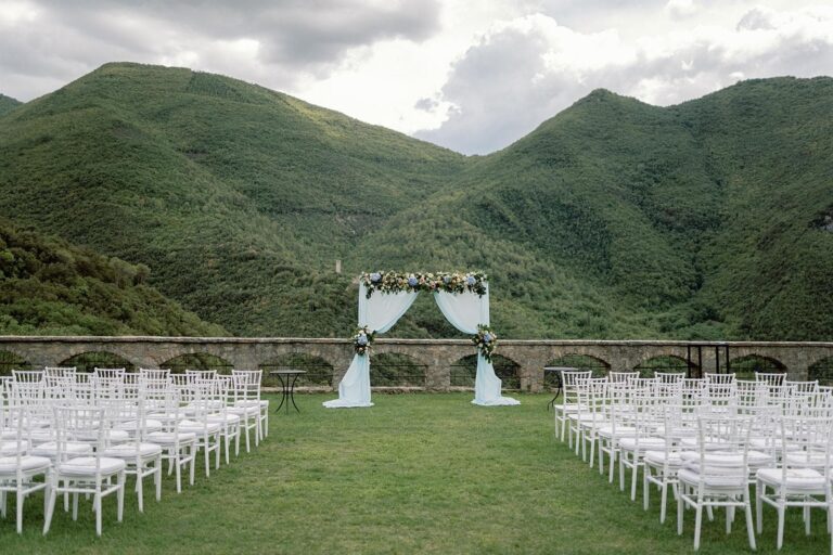 Chairs set on the abbey lawn, wooded mountains closing the valley, Umbria Weddings and Events