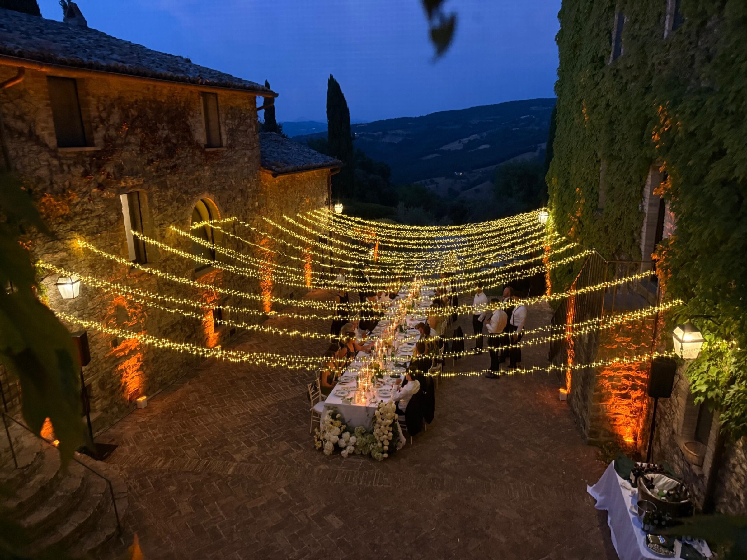 UMX Crew: Festoon lighting over a terrace dinner