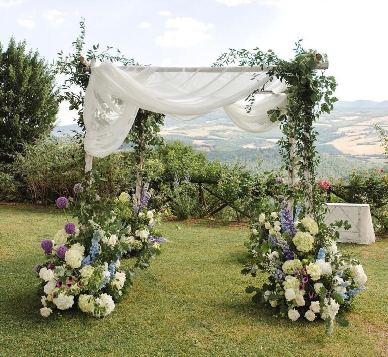 UMX Crew: A floral ceremony arch with drapes