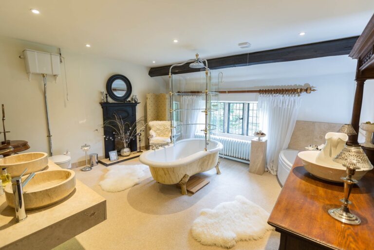 The family bathroom with a roll-top bath, twin basins and a fireplace, Upper House Hayfield