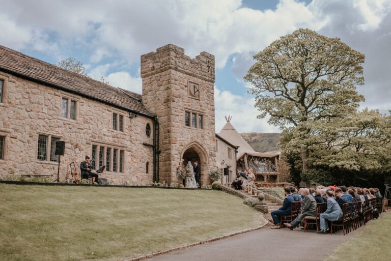 An outdoor ceremony on the front lawn beneath the Solstice Tower, Upper House Hayfield