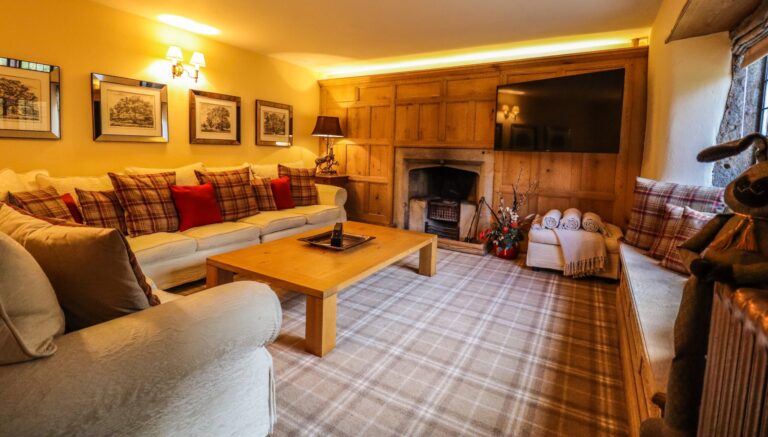 The Snug, a panelled sitting room with tartan carpet and an open fire, Upper House Hayfield