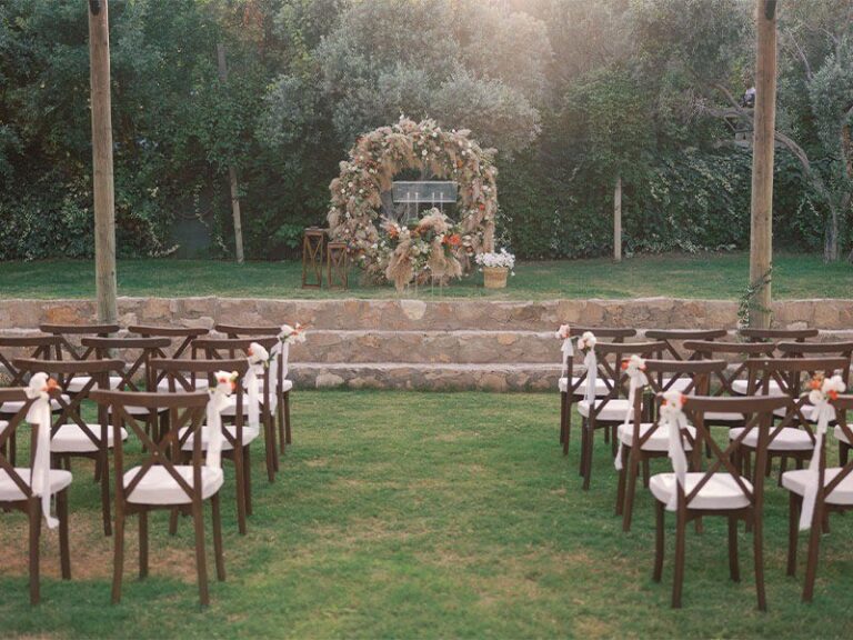 Rows of wooden chairs facing a floral ceremony arch, Urla Sahne