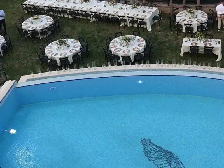 Tables set on the lawn beside the pool, Urla Sahne