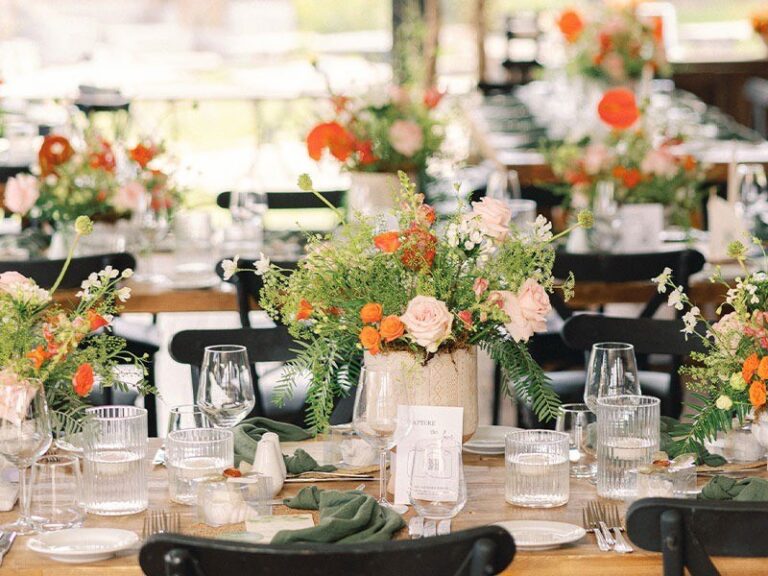 A table set with candles and an orange and white floral centrepiece, Urla Sahne