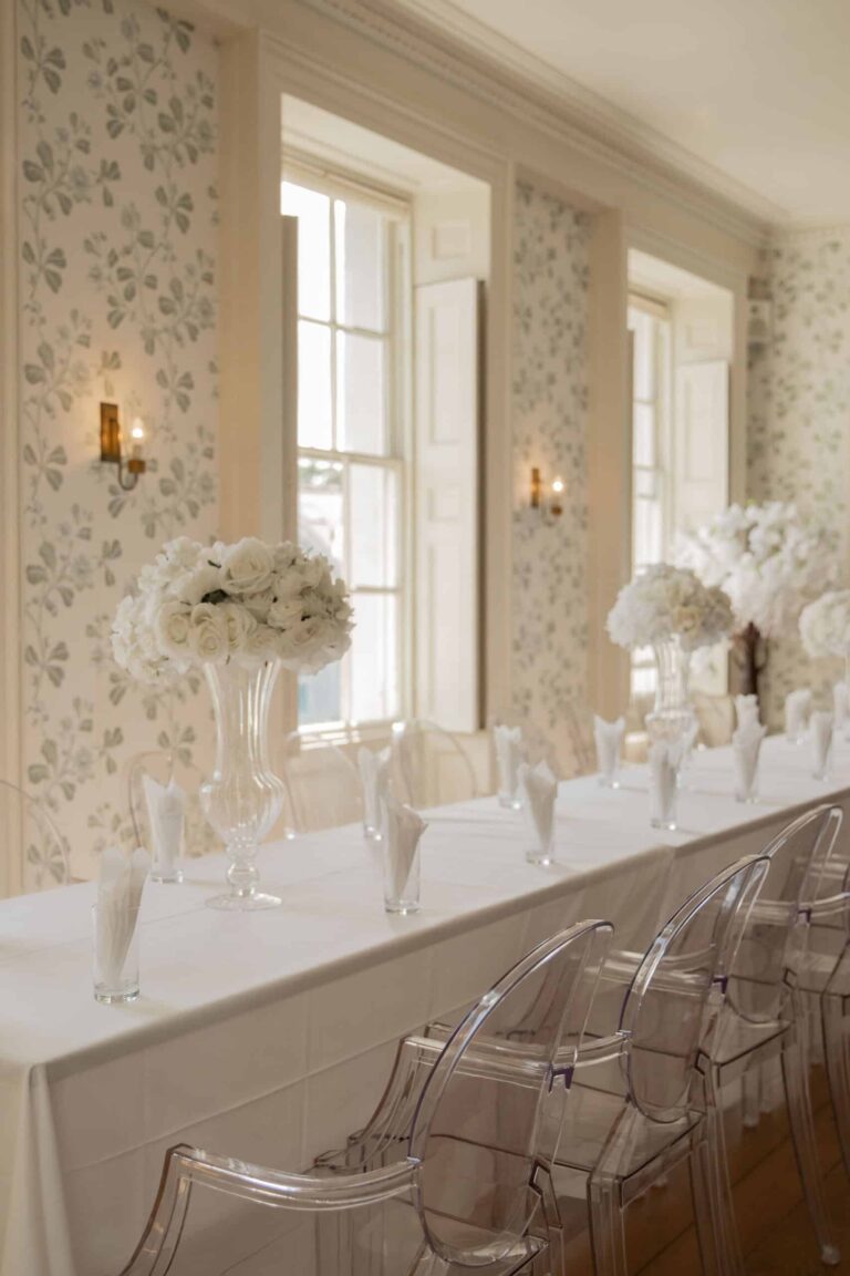 Place settings and white florals along a dressed table with ghost chairs, Valentines Mansion & Gardens