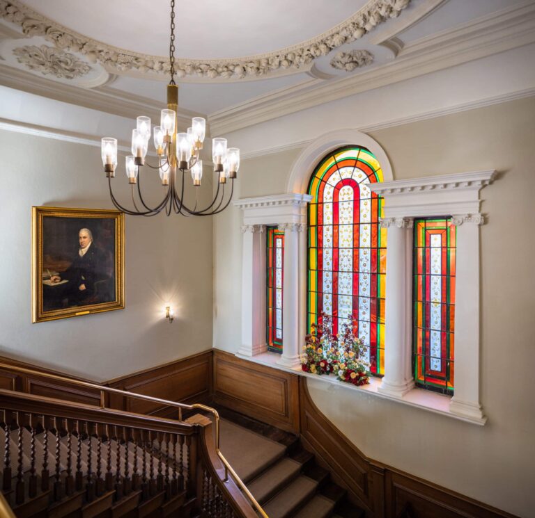 The grand staircase rising past the coloured-glass window, Valentines Mansion & Gardens