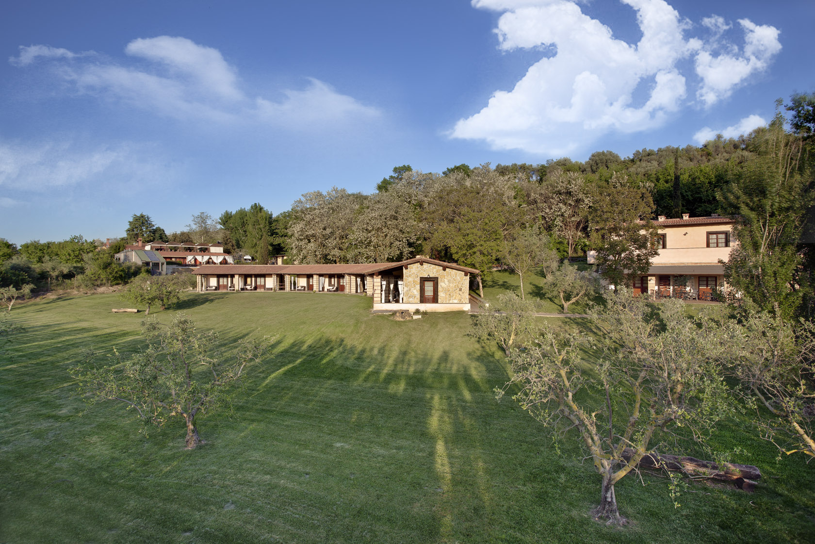The low stone buildings across the olive lawn, Valle del Marta