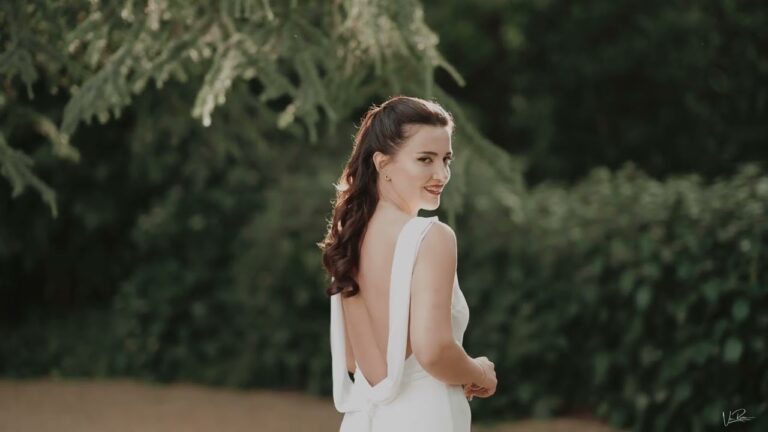 A bride looking back over her shoulder in the gardens of Château Challain-la-Potherie, France, Vic Rivero Films