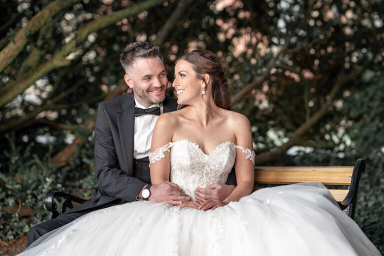 Bride and groom on a garden bench under the trees, Tyn Dwr Hall, Wales, Victoria Amrose Photography