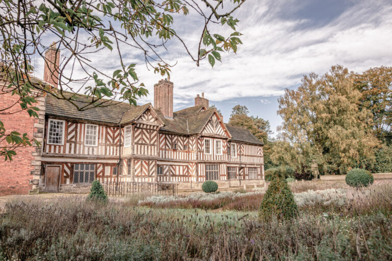 Adlington Hall's black-and-white timbered front seen across the gardens, Cheshire, Victoria Amrose Photography