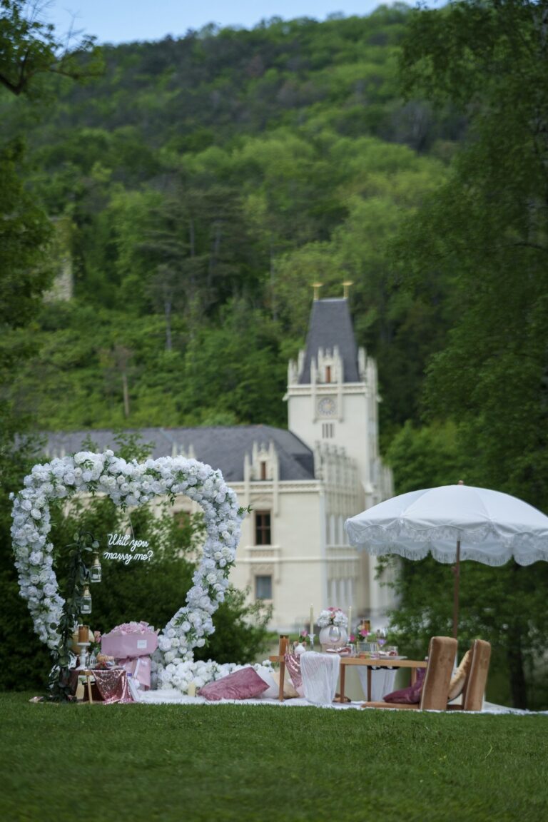 White floral heart arch and parasol picnic before a castle in the woods, Vienna Picnics