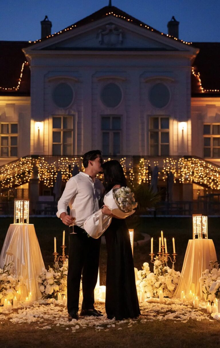 Couple embracing before a candlelit castle with fairy lights at dusk, Vienna Picnics