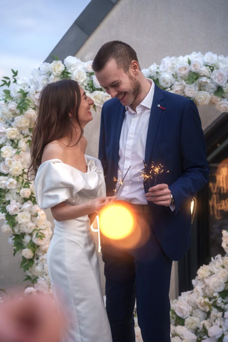Couple with sparklers in front of a white floral arch, Vienna Picnics