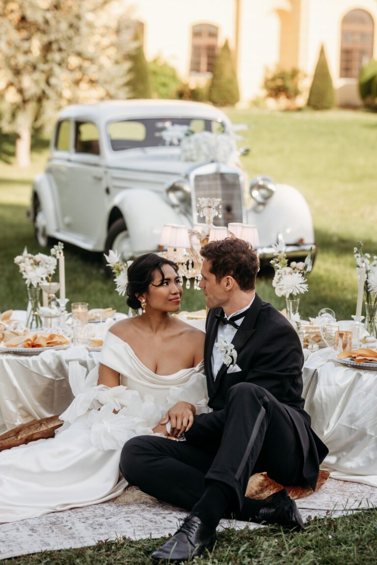 Elopement picnic couple seated on the lawn with a vintage car behind, Vienna Picnics