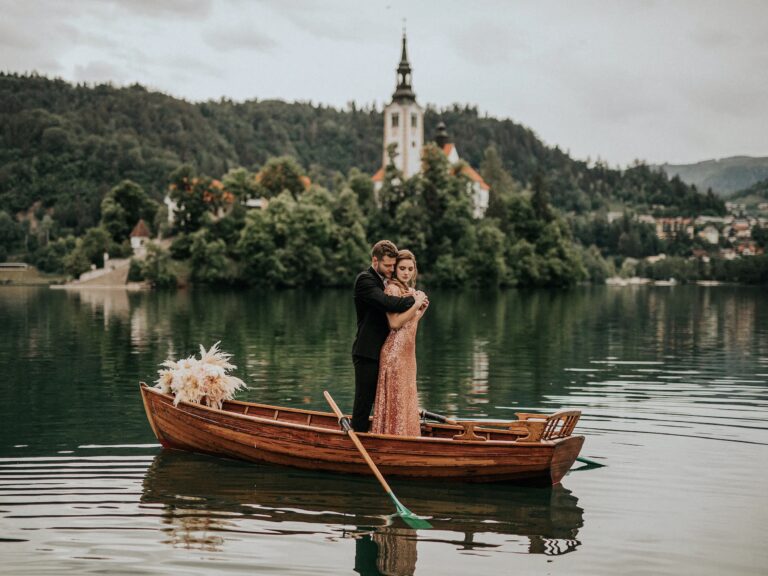 Couple in a wooden boat with the church on Bled Island behind, Vila Bled