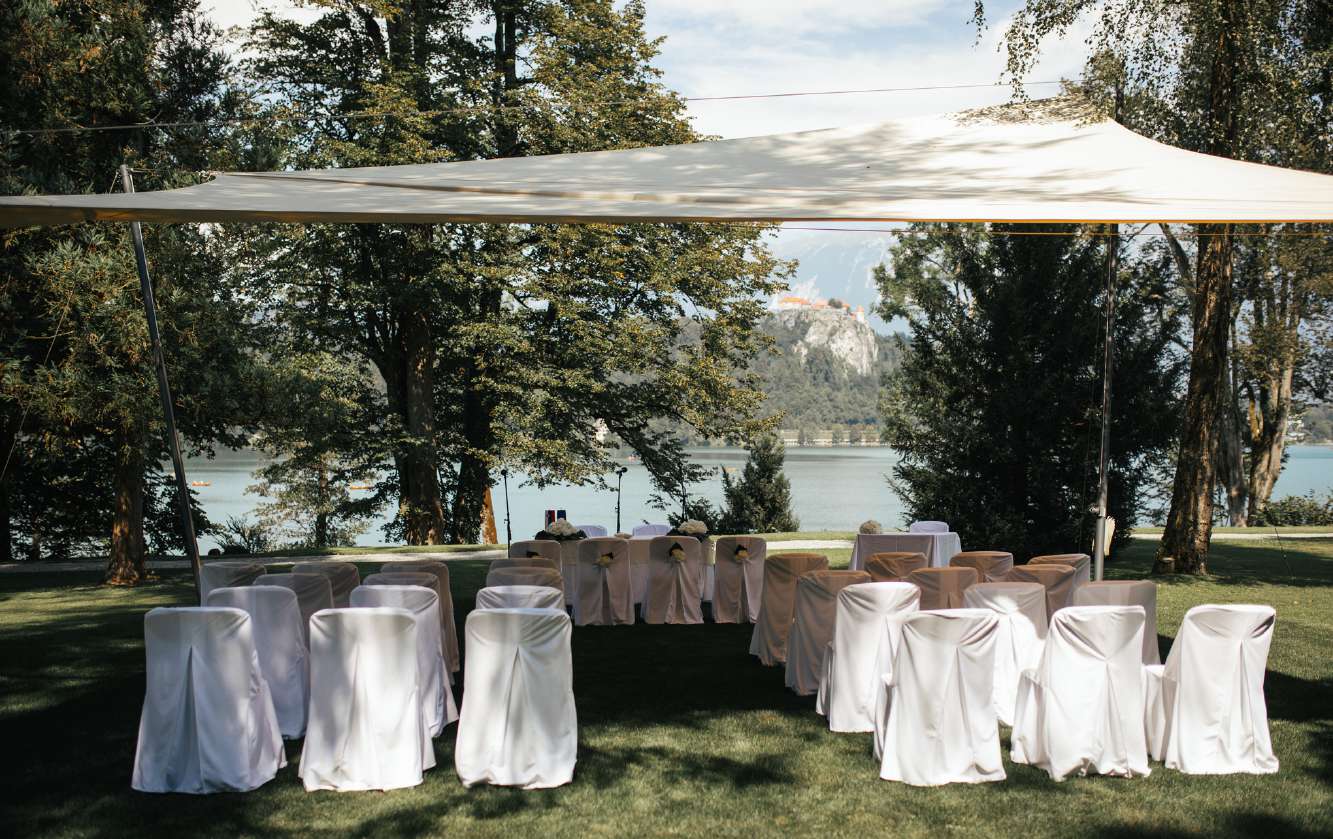 Ceremony seating on the lawn under a canopy, with the lake behind, Vila Bled