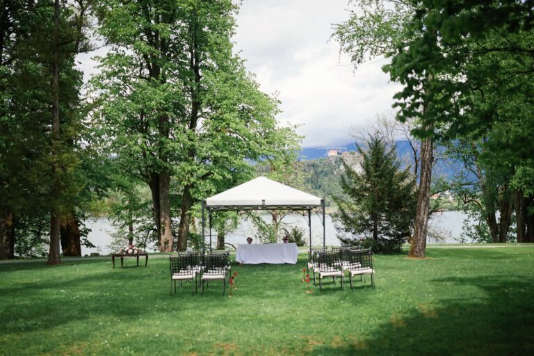 A ceremony set on the lawn with a white gazebo and the lake beyond, Vila Bled