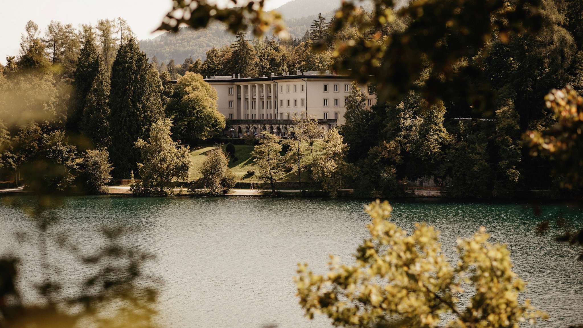 Vila Bled seen across Lake Bled through the trees, Vila Bled