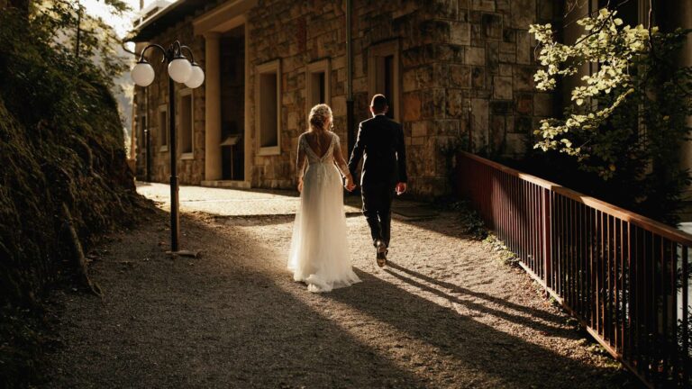 Couple walking along a stone path beside the villa grounds, Vila Bled