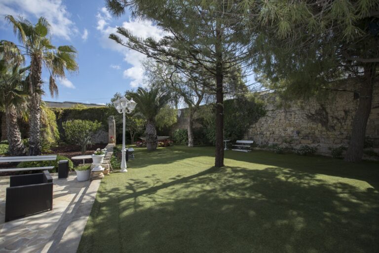A lawn and stone wall in the gardens, Villa Arrigo