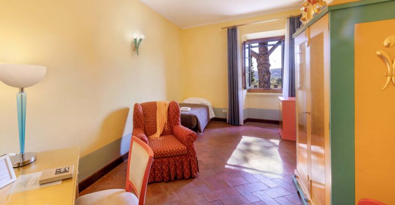 Guest room with armchair and painted wardrobe, Villa Castiglione