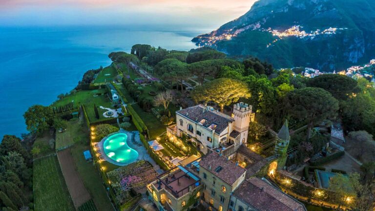 The villa and pool lit at dusk above the sea, Villa Cimbrone