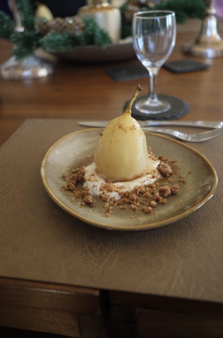 A poached pear dessert on a laid table, Villa la Tosca